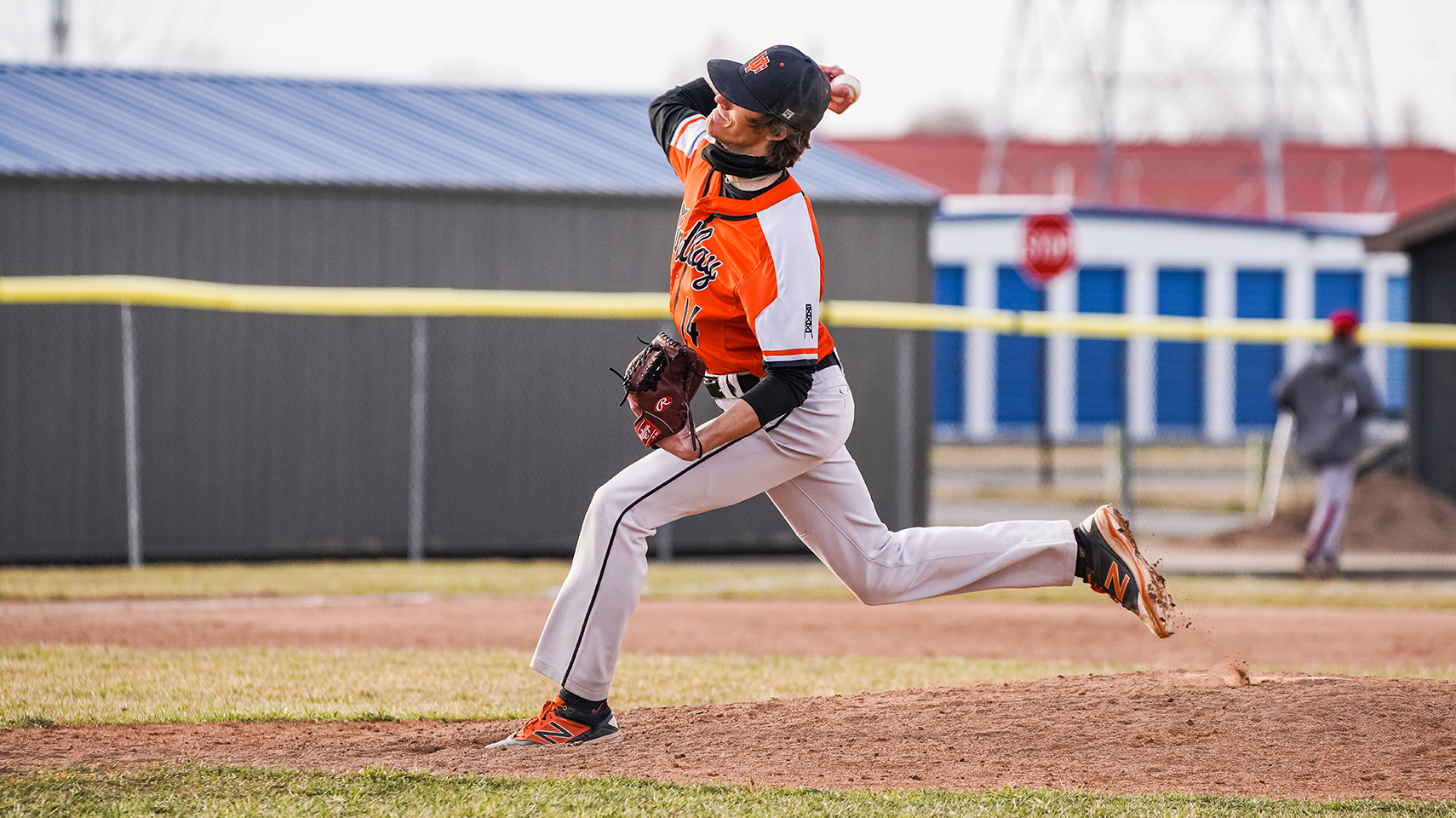 Pitcher in orange throwing the ball 