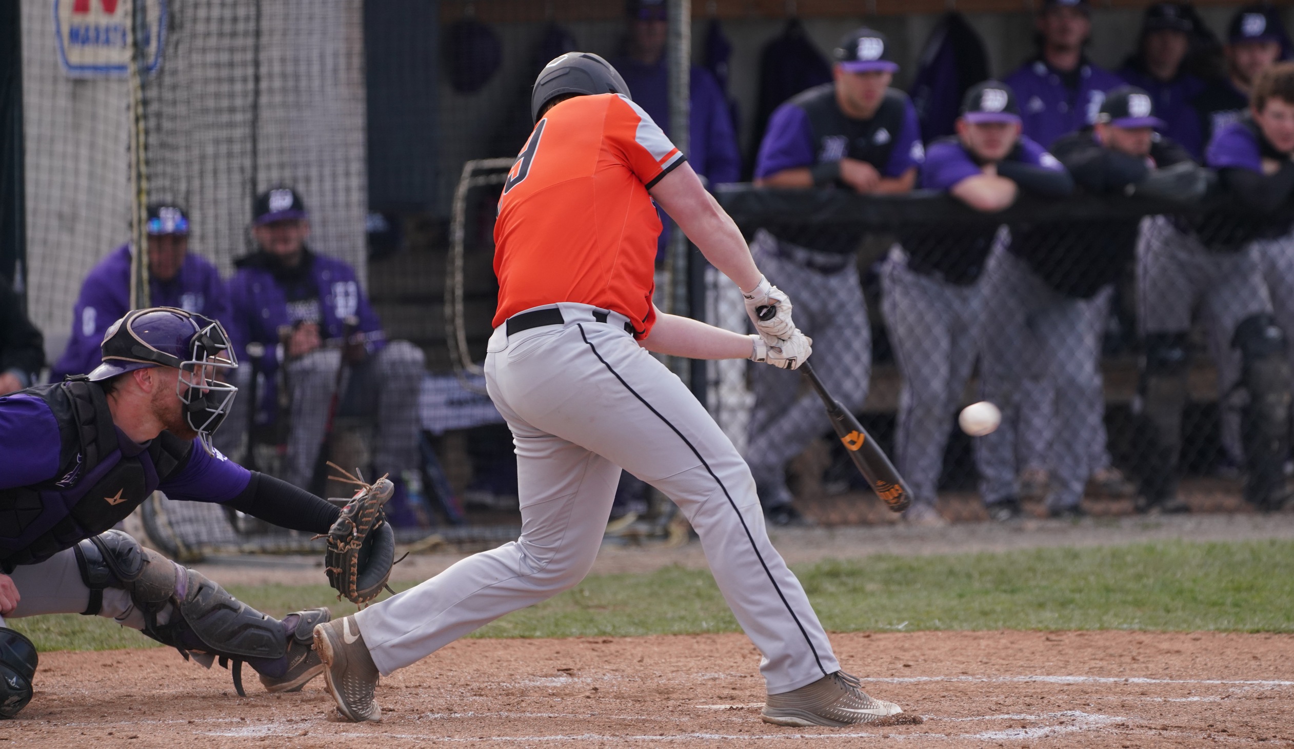 baseball player in orange jersey hitting left handed

