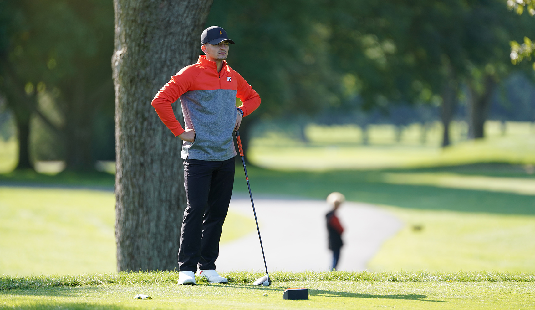 Male golfer looks on to fairway