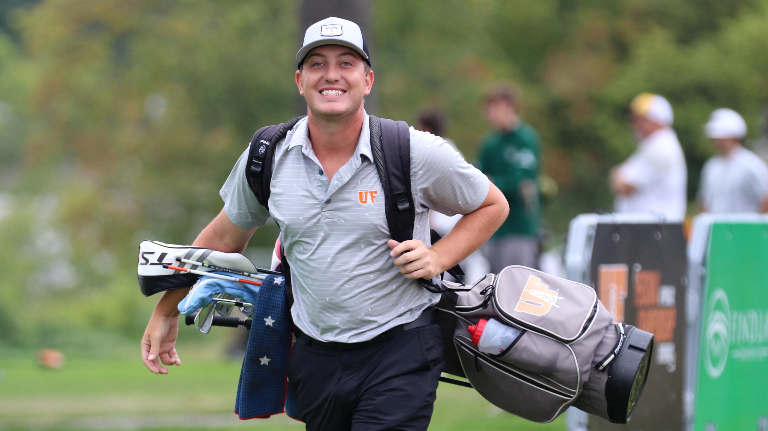 Player smiles while walking on course. 