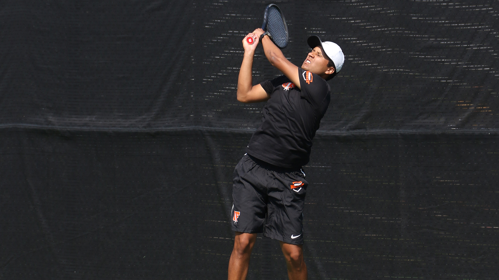 Men's tennis player jumping to hit the ball