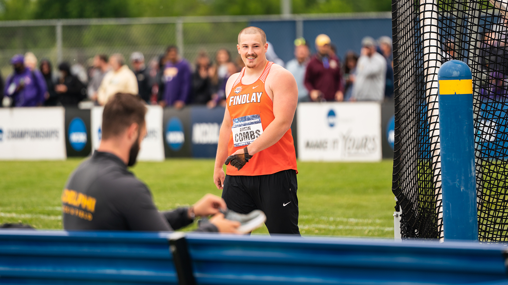 Men's track athlete in orange smiling