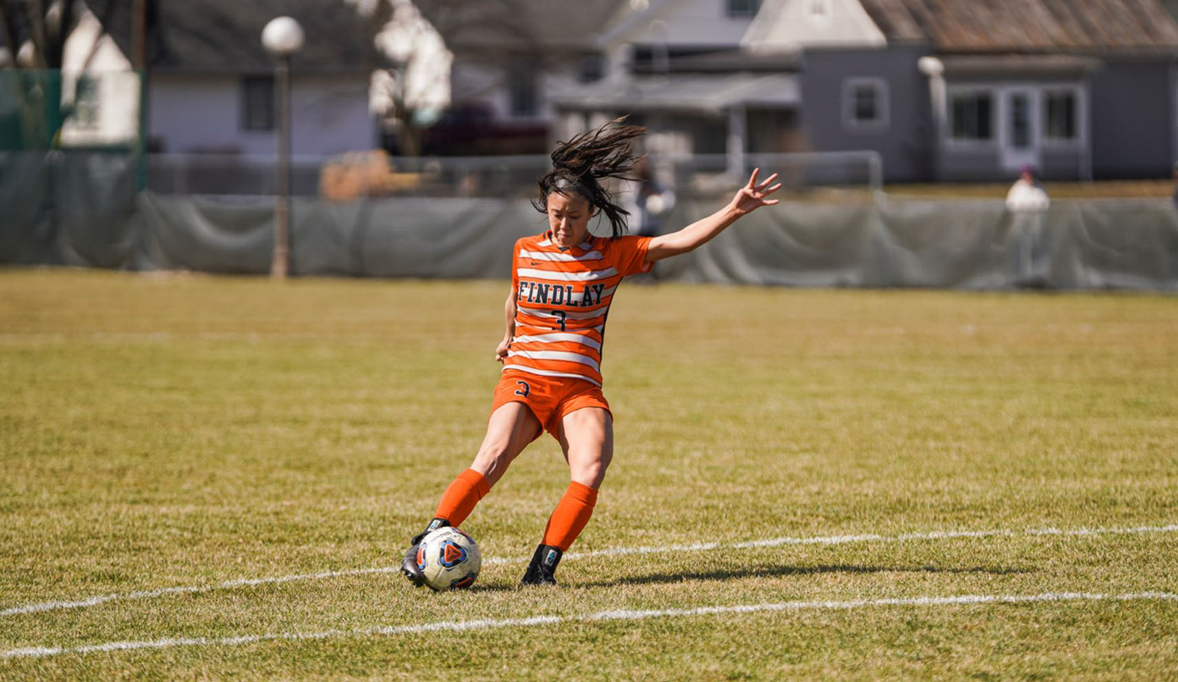 Woman kicking soccer ball