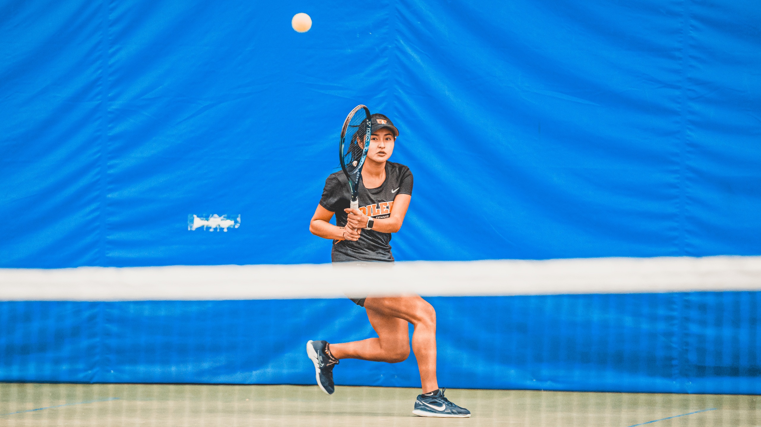 girl in black playing tennis