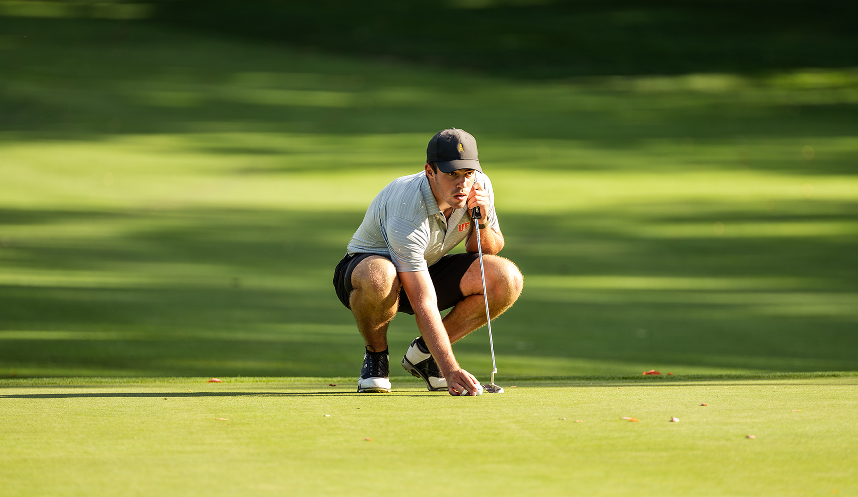 Male golfer eyeing up a putt