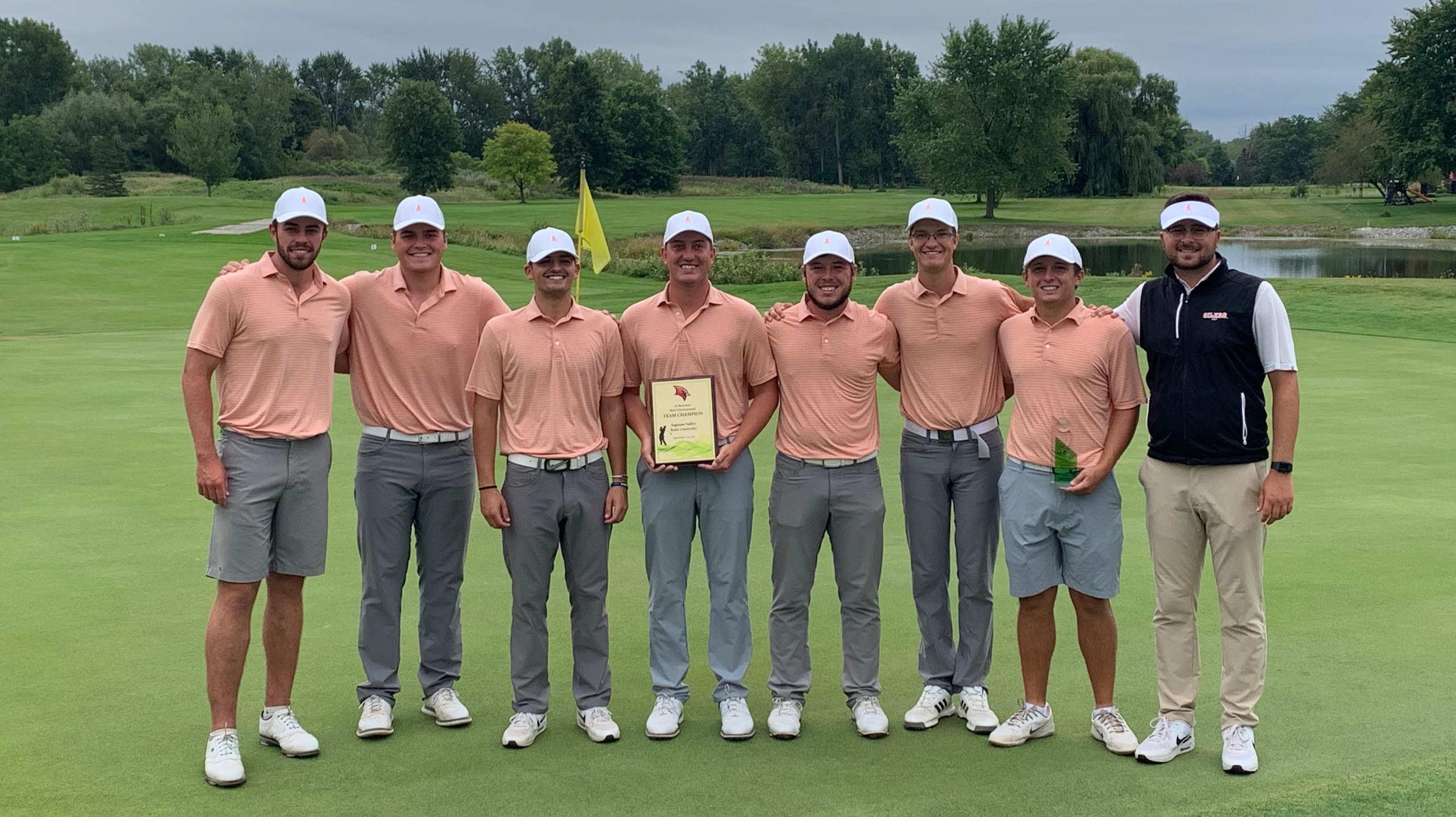 Mens golf team poses with trophy.