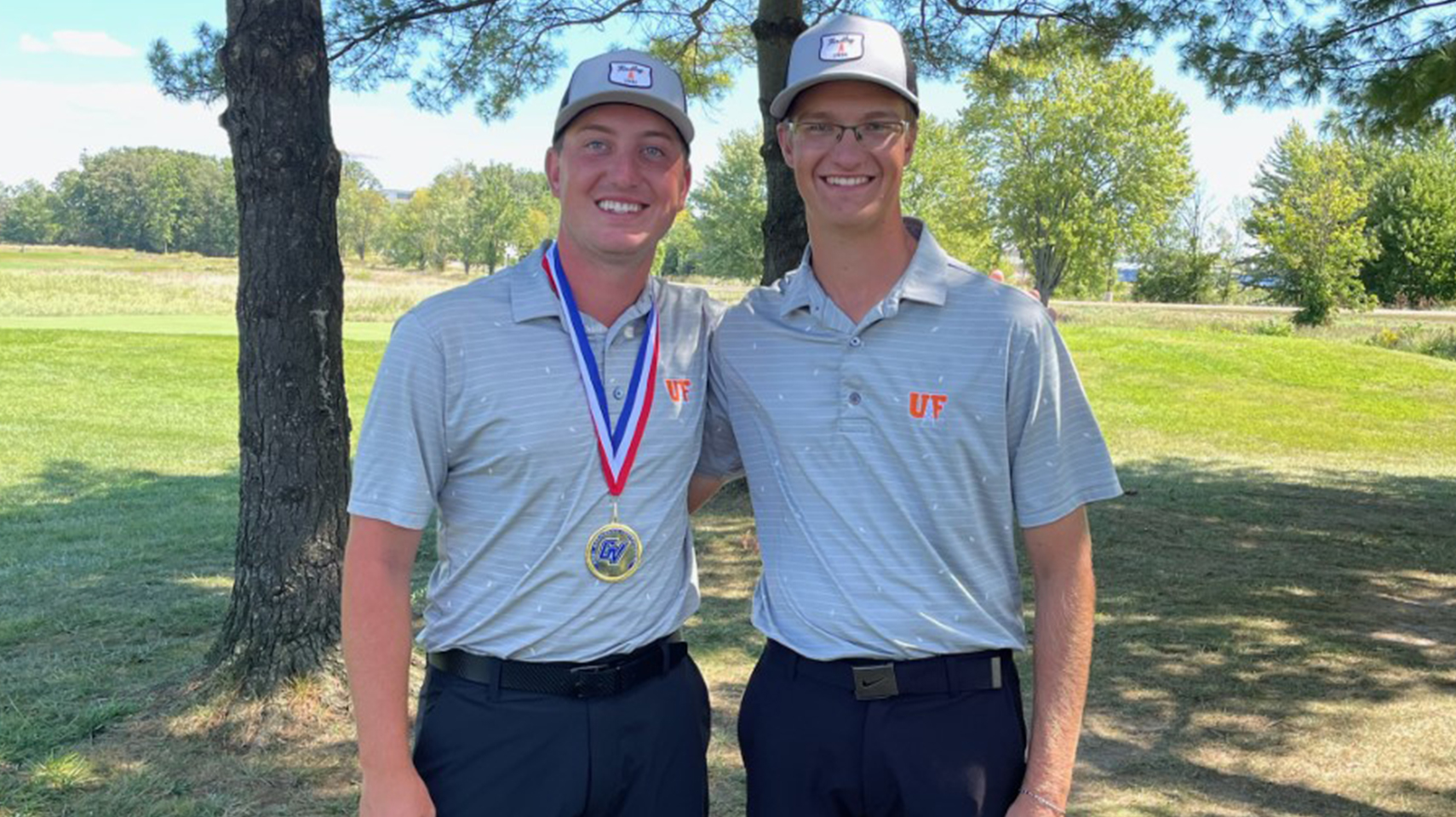 Two men's golfers in gray posing for an all-tournament picture