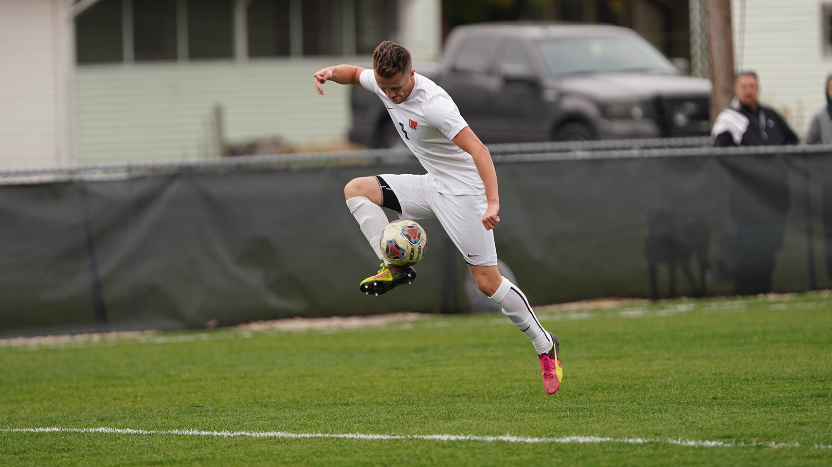 Men's soccer player in white trapping the ball