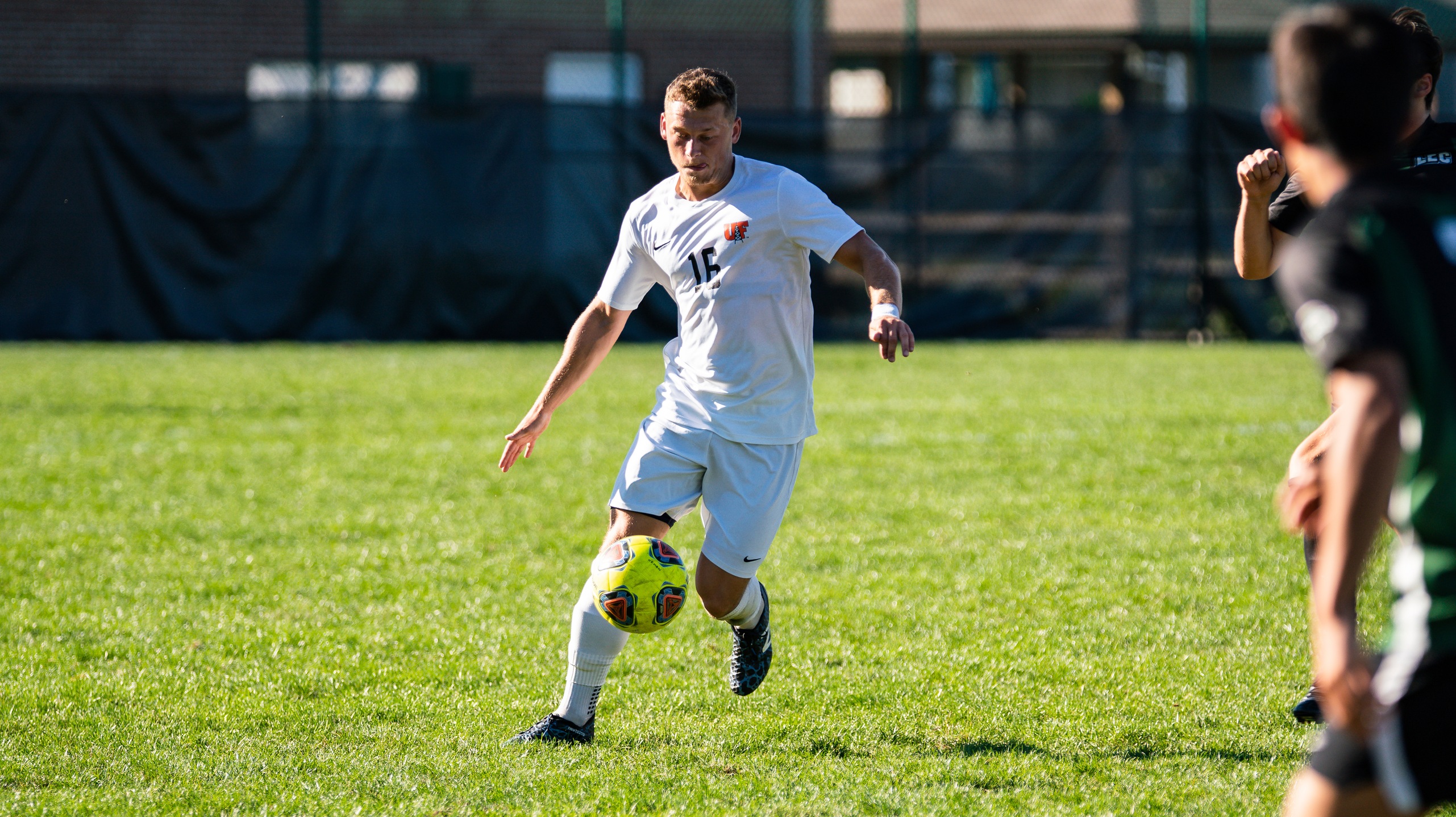 Player in white dribbling ball down field

