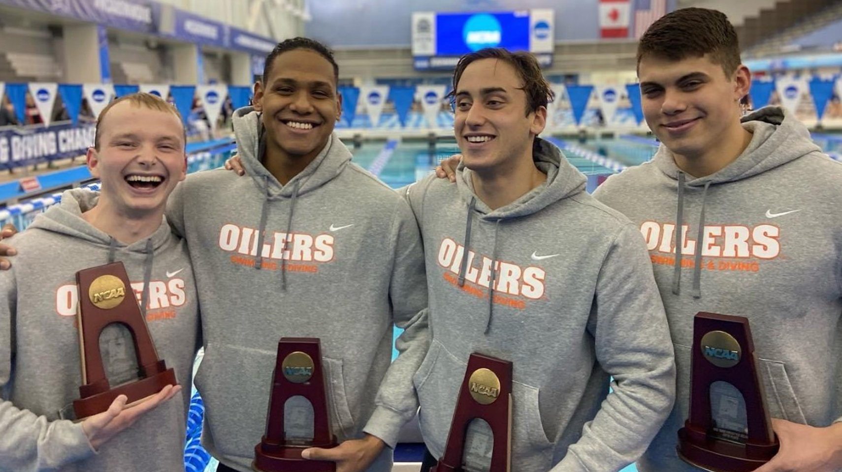 Men's swimmers smiling after earning all-american honors at the NCAA DII national championship