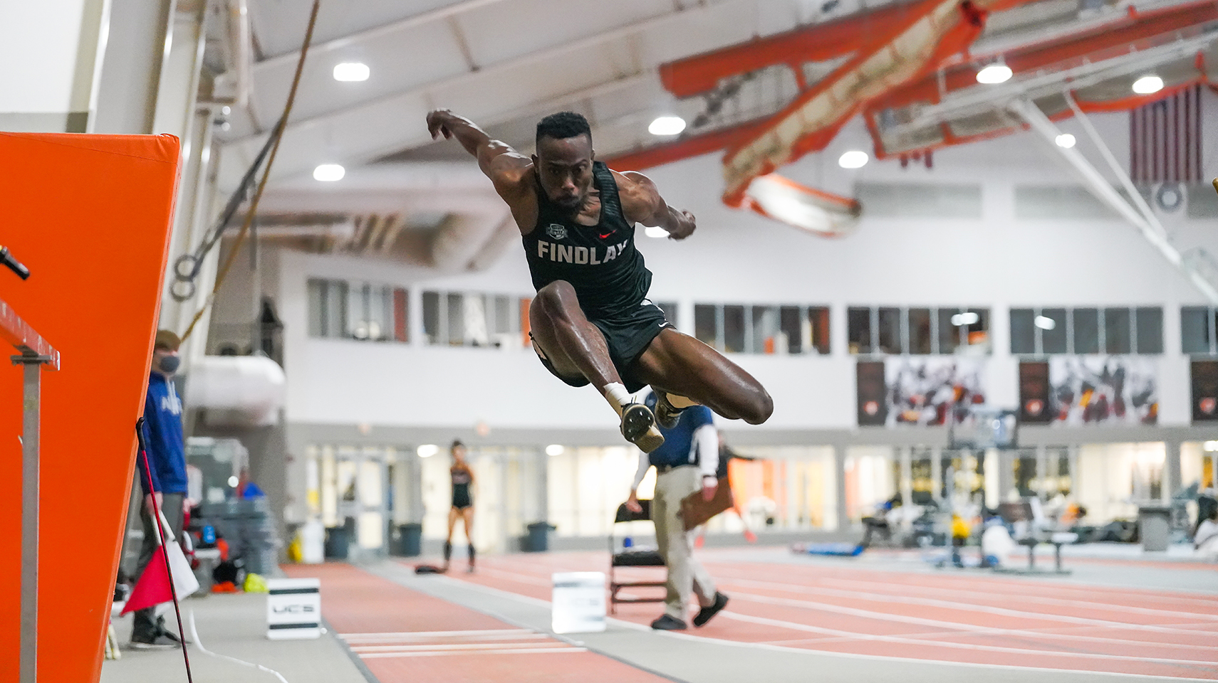 Men's track athlete jumping high in the air