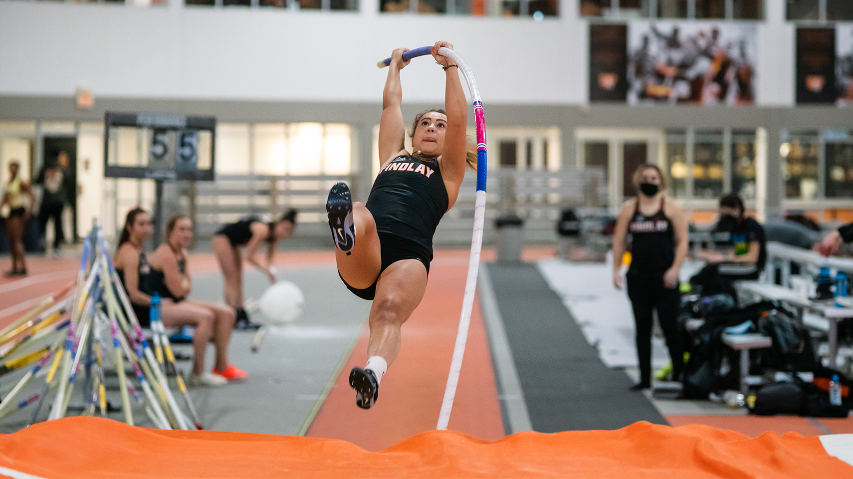 Women's pole vaulter lifting off the ground