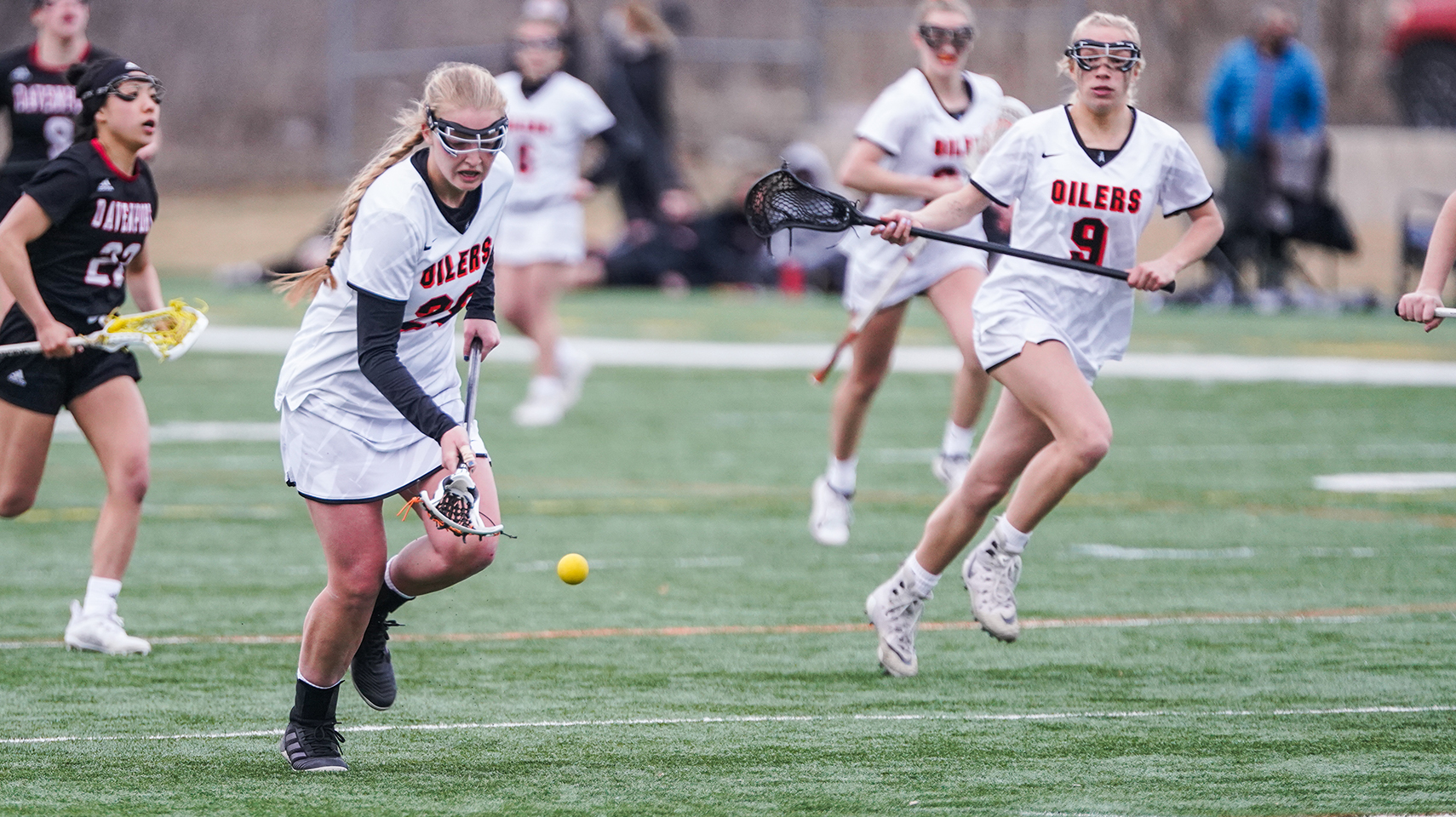 Women's lacrosse player picking up a ground ball