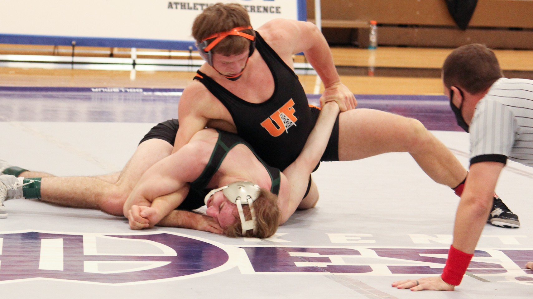 Wrestler forcing an opponent into the mat