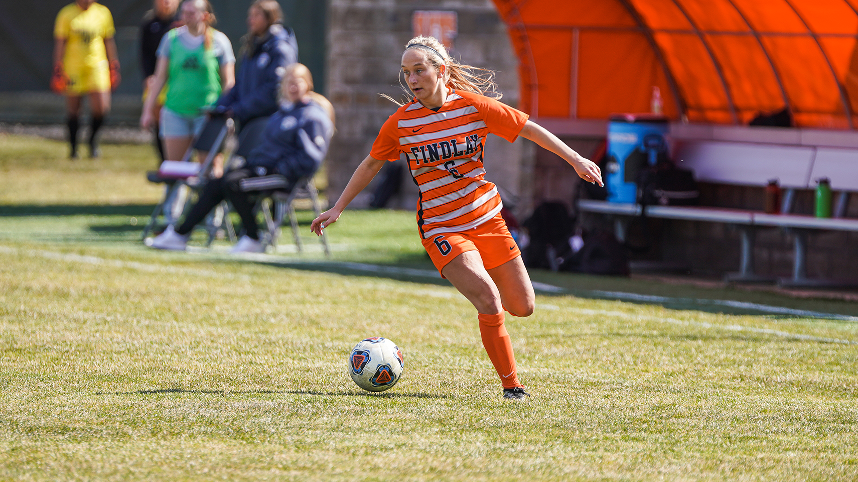 women's soccer player in orange running