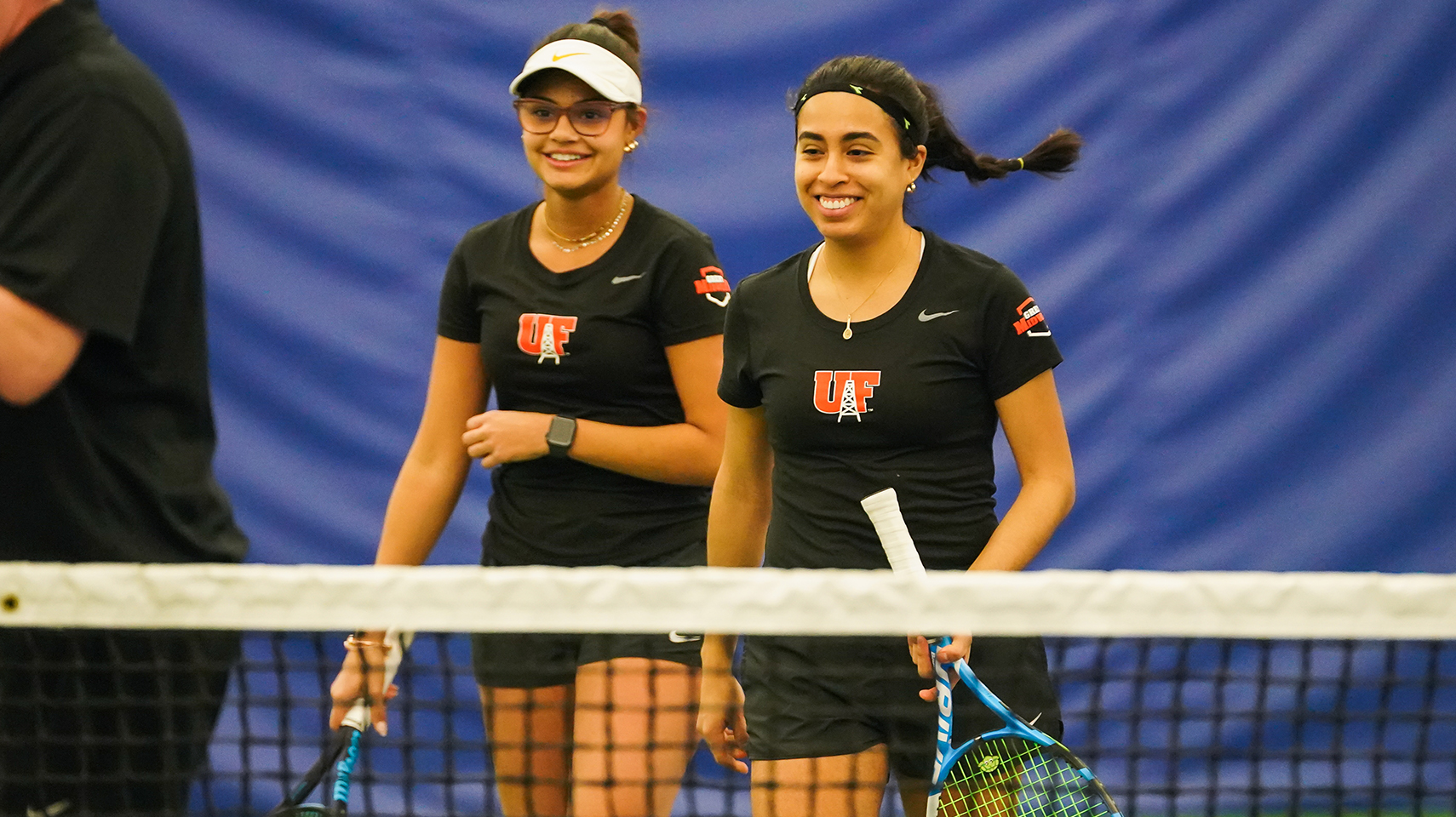 Women's tennis players in black smiling