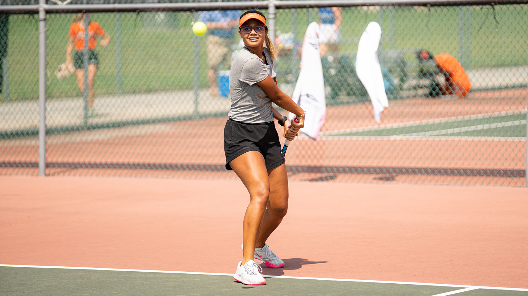 Women's tennis player returning a ball over the net