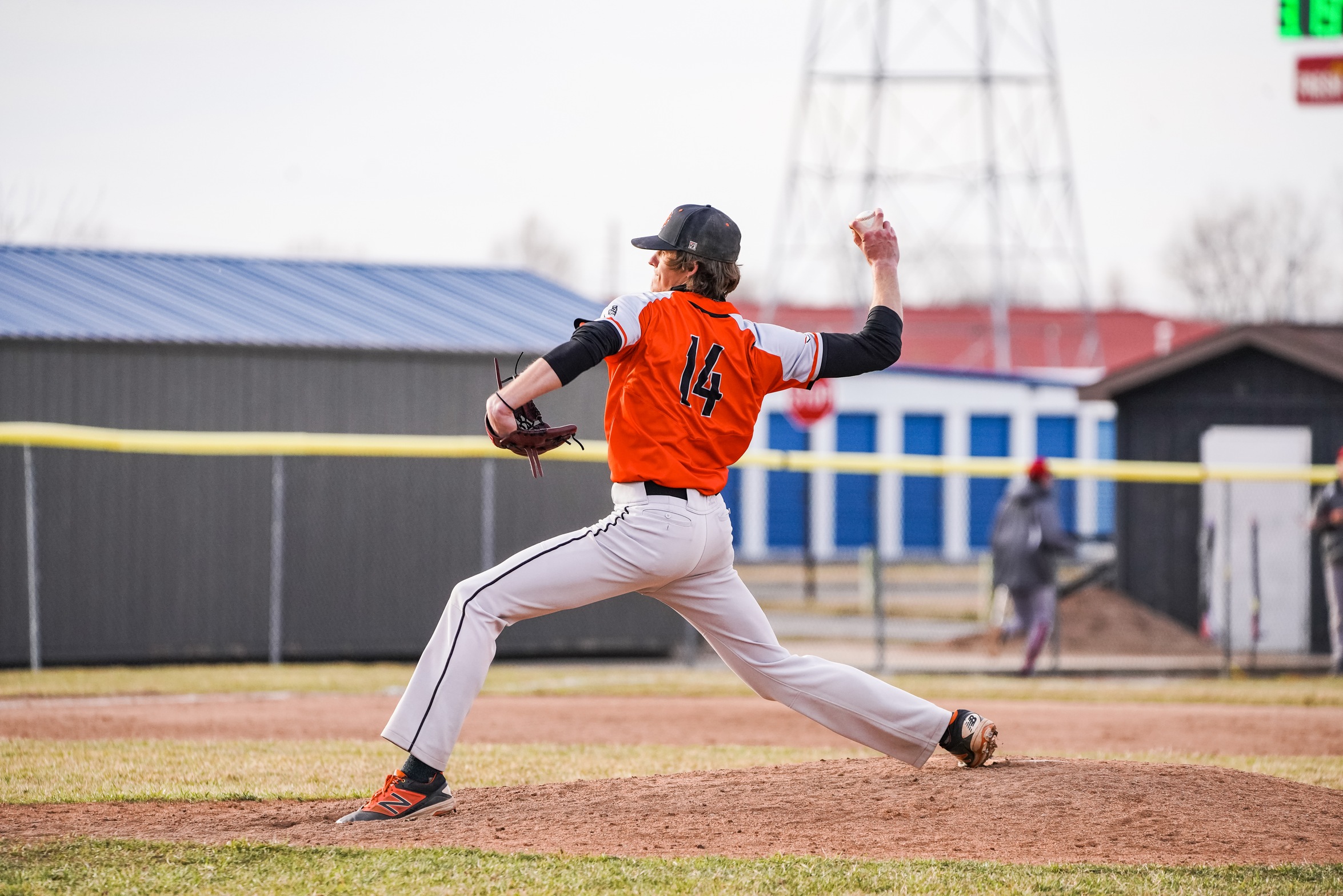pitcher in orange throwing hard