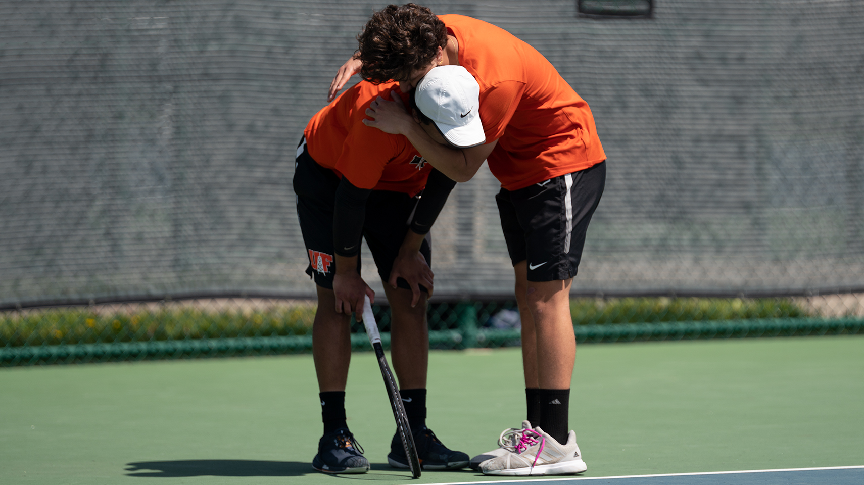 Men's tennis players hugging